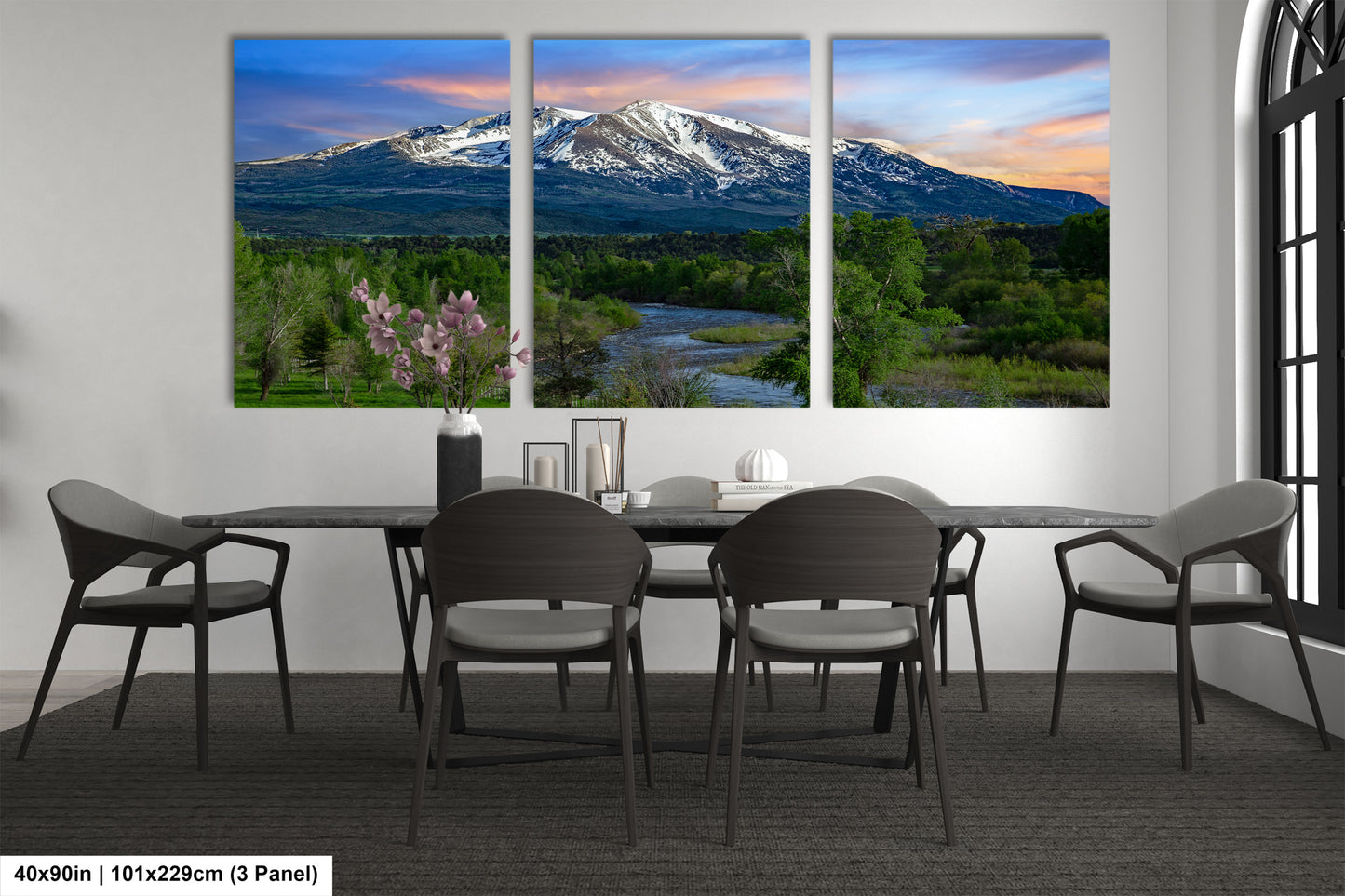 a dining room table with four chairs and a mountain in the background