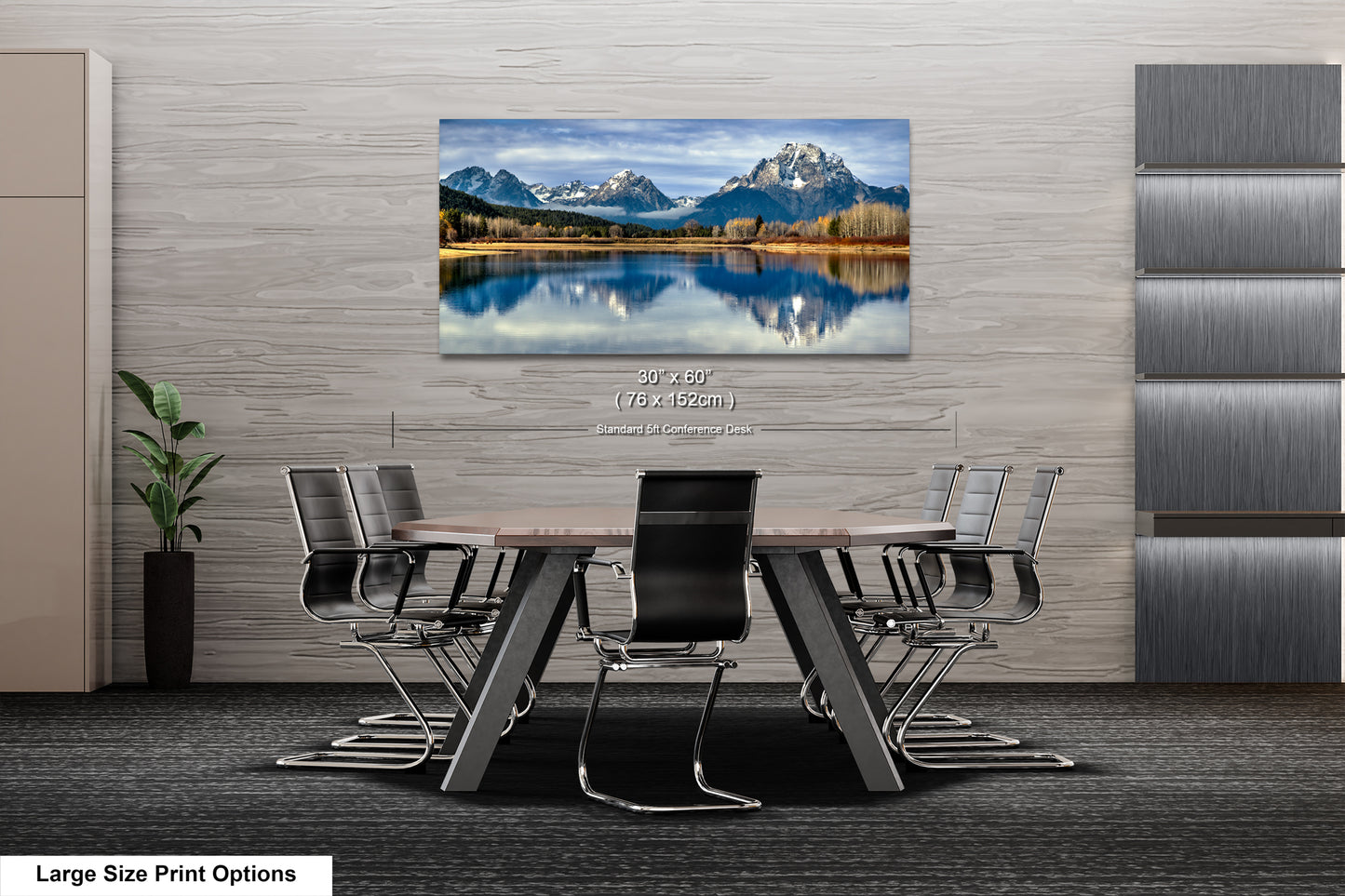 A large landscape painting depicting a serene mountain lake is displayed on the wall of a modern office space, with a conference table and chairs arranged in front of it.