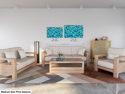 a modern living room with a white sofa, two chairs, and a coffee table. The room has a geometric patterned rug on the floor. There are two framed artworks hanging on the wall, one depicting a blue water surface and the other showing a blue sky. The image also includes text that provides information about the medium size print options for the artworks.