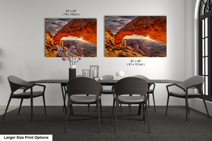 a dining room table with four chairs and two pictures on the wall