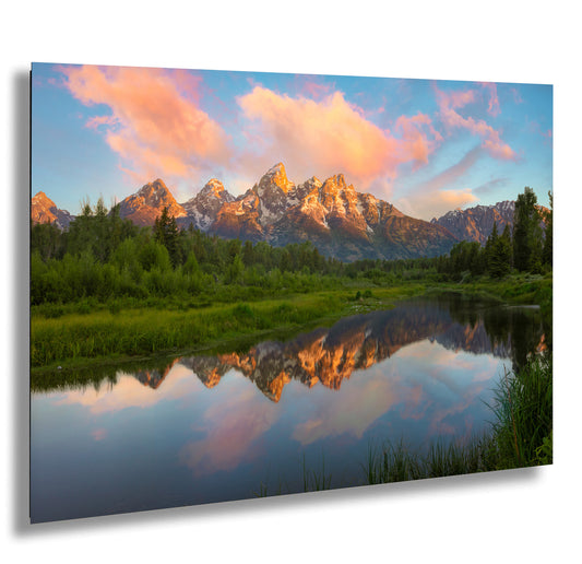 a mountain range is reflected in the still water of a lake