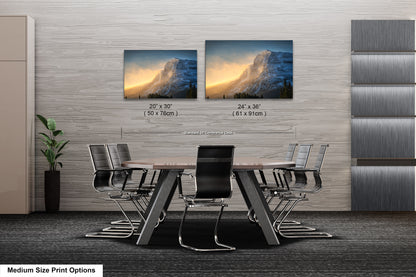a dining room table with four chairs and two pictures on the wall