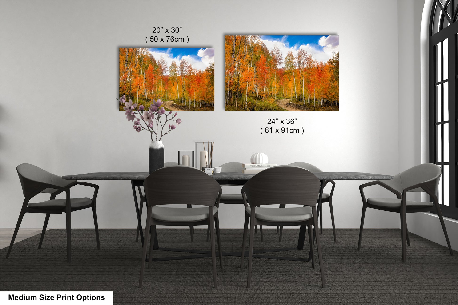 a dining table with four chairs and a vase with flowers