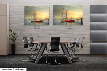 a dining room table with chairs and two pictures of boats on the wall