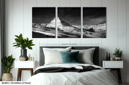 a black and white photo of a bed with a mountain in the background