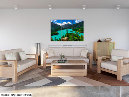 The image is a modern living room with a large, colorful landscape painting hanging on the wall. The painting depicts a scenic mountain view with a lake and trees. The room is furnished with a sofa, two chairs, and a coffee table. The overall design and decor create a comfortable and inviting atmosphere.
