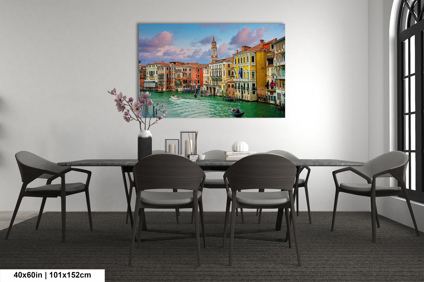 a dining room table with chairs and a painting on the wall