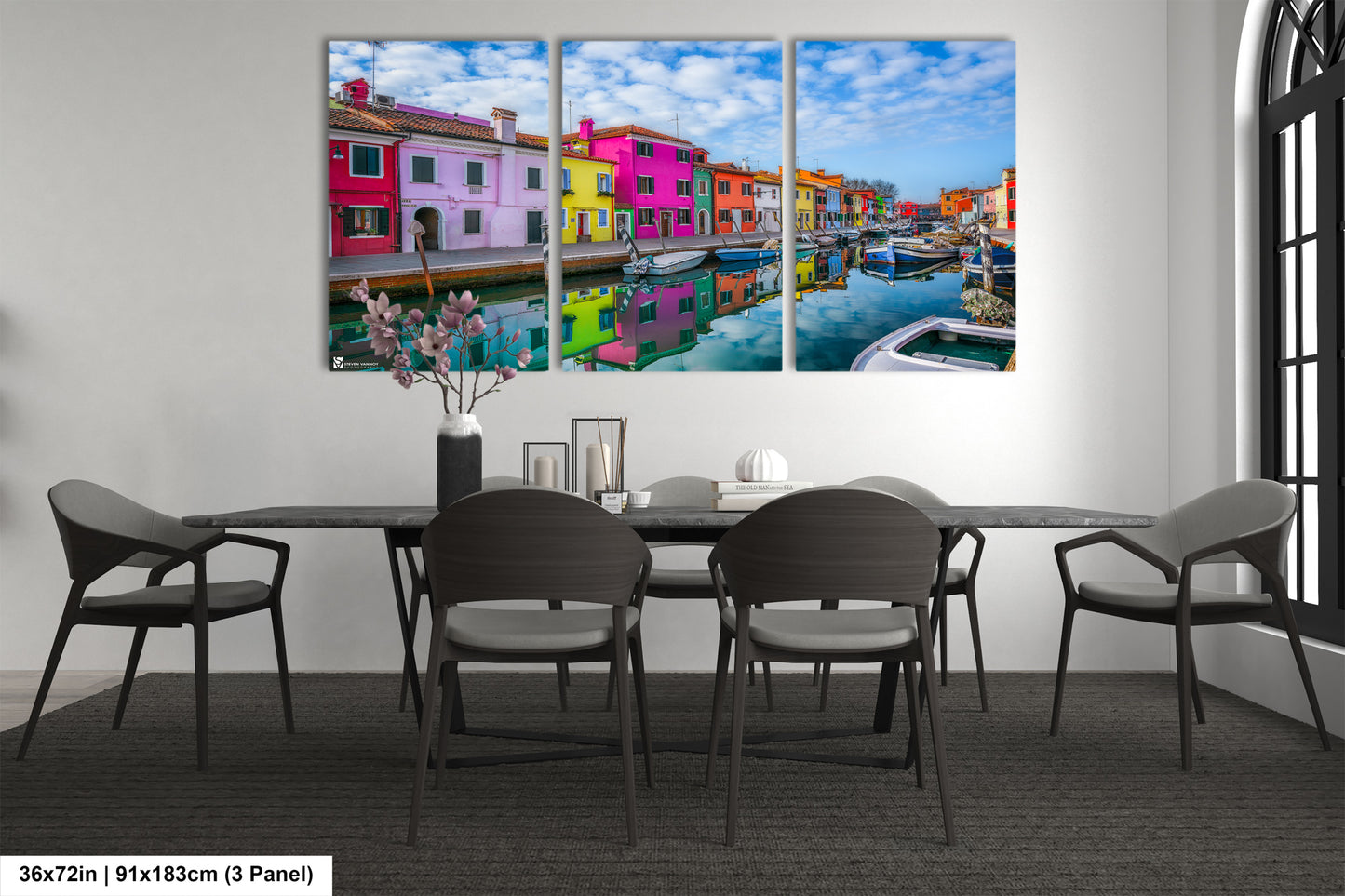 a dining room table with chairs and a painting on the wall