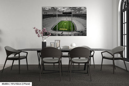a dining room table with chairs and a painting of a football field
