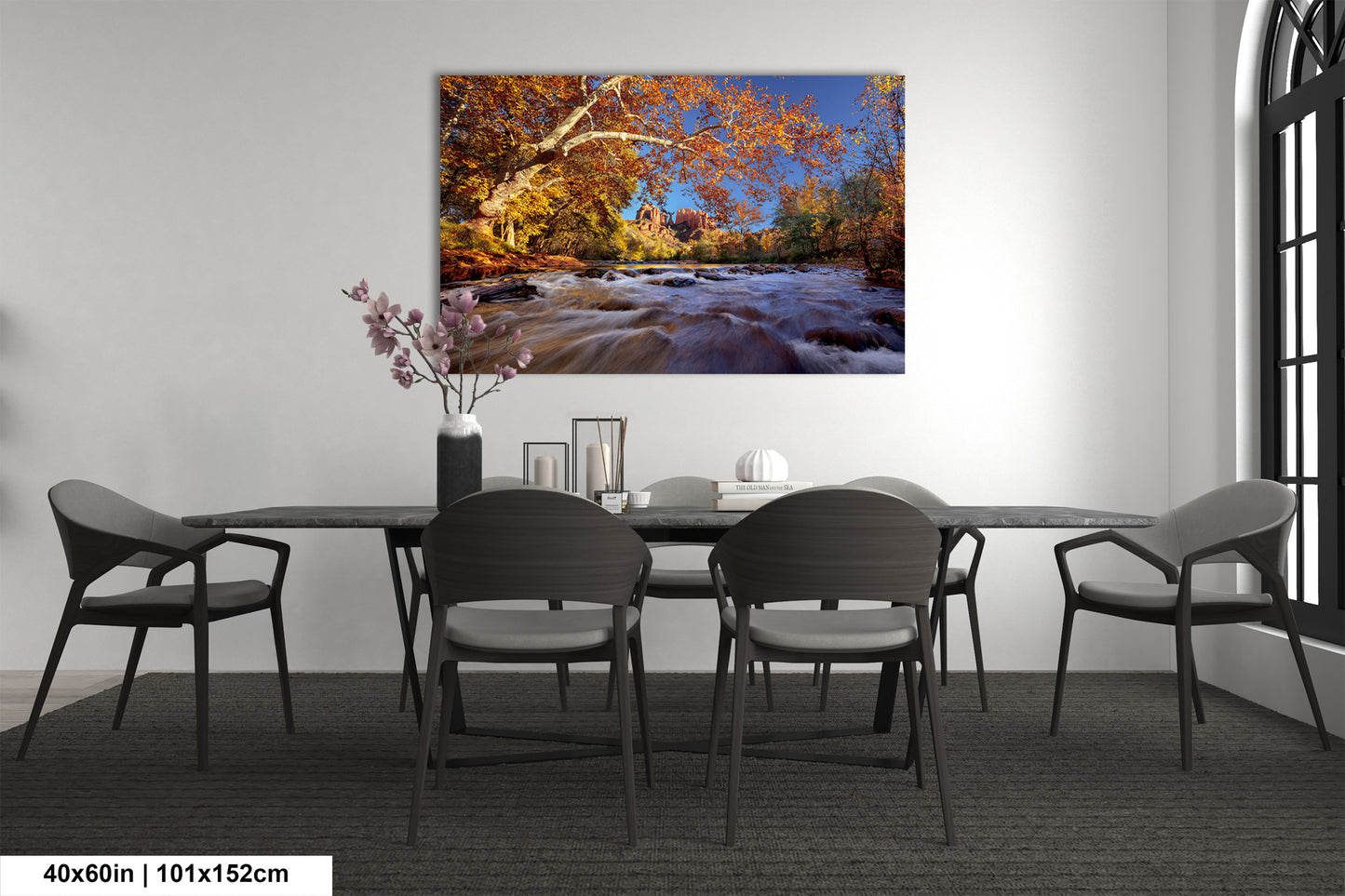 a dining room table with chairs and a painting on the wall