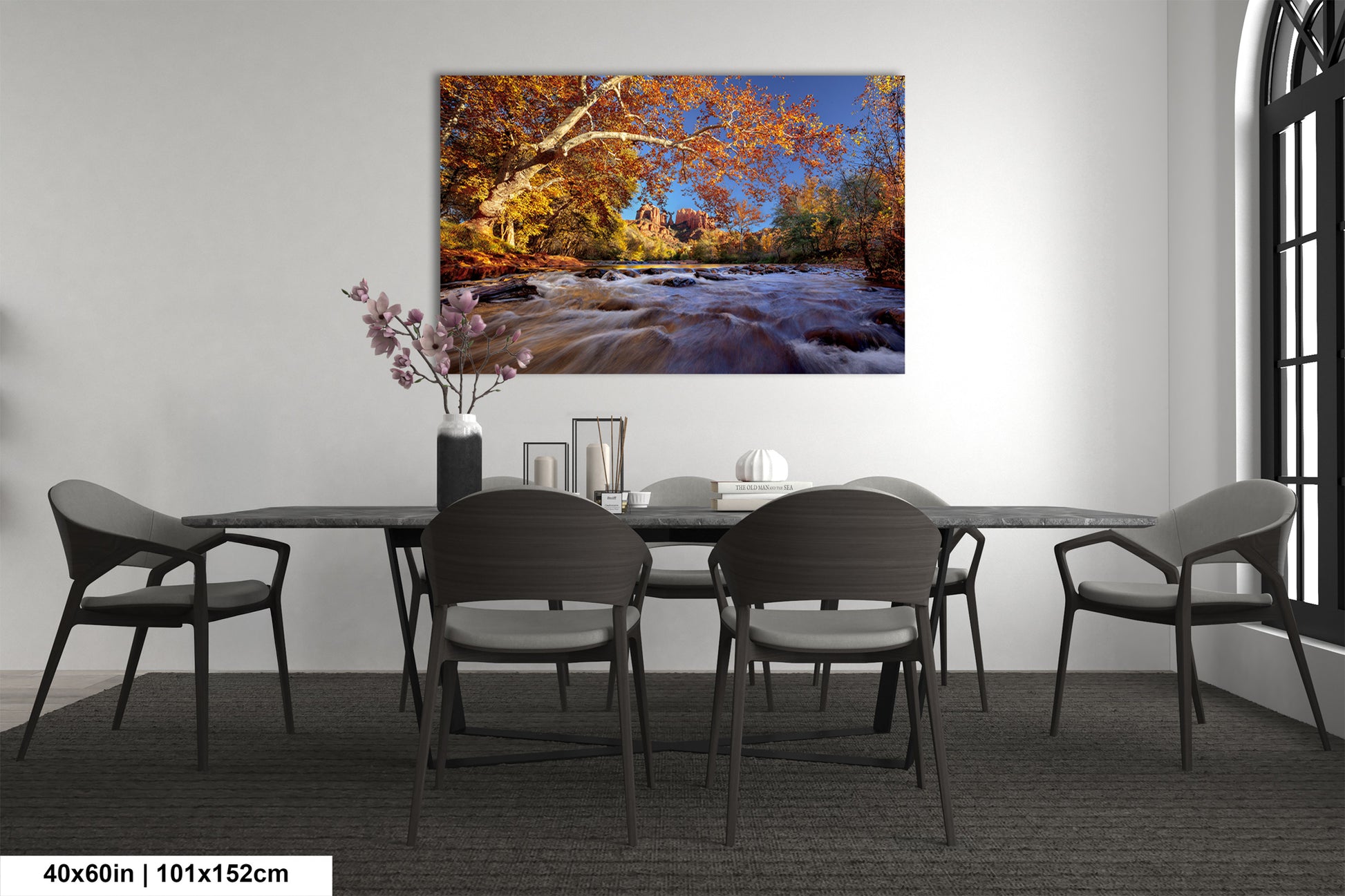a dining room table with chairs and a painting on the wall