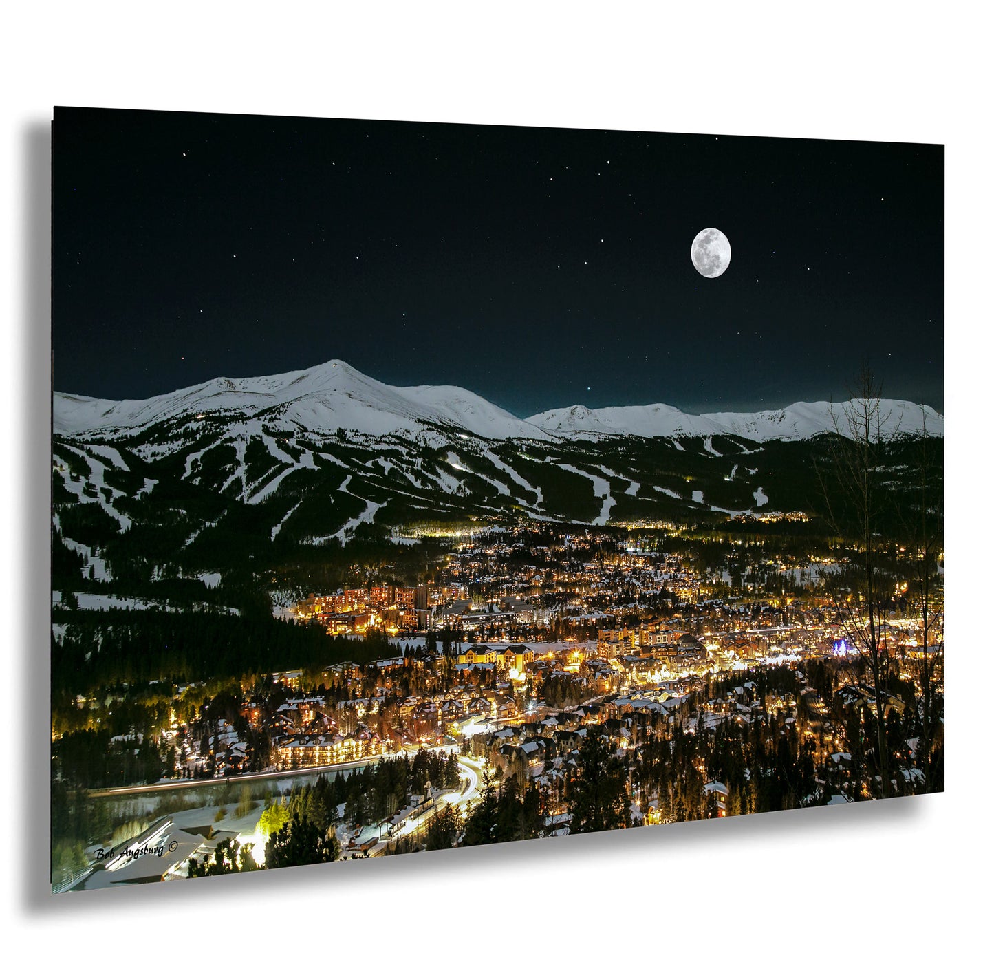 a night view of a city with a full moon in the sky