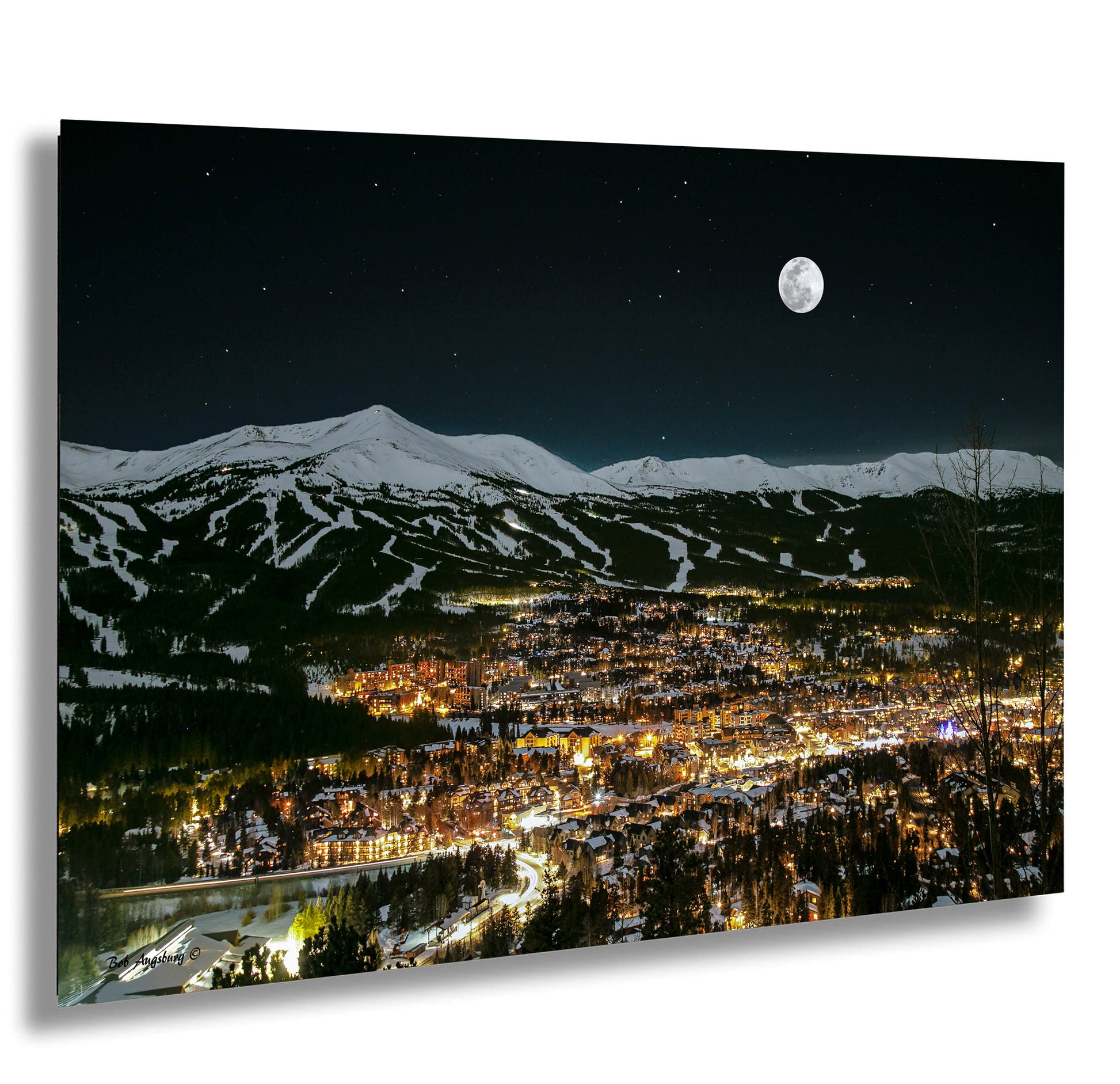 a night view of a city with a full moon in the sky