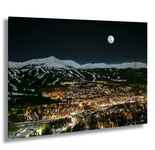 a night view of a city with a full moon in the sky
