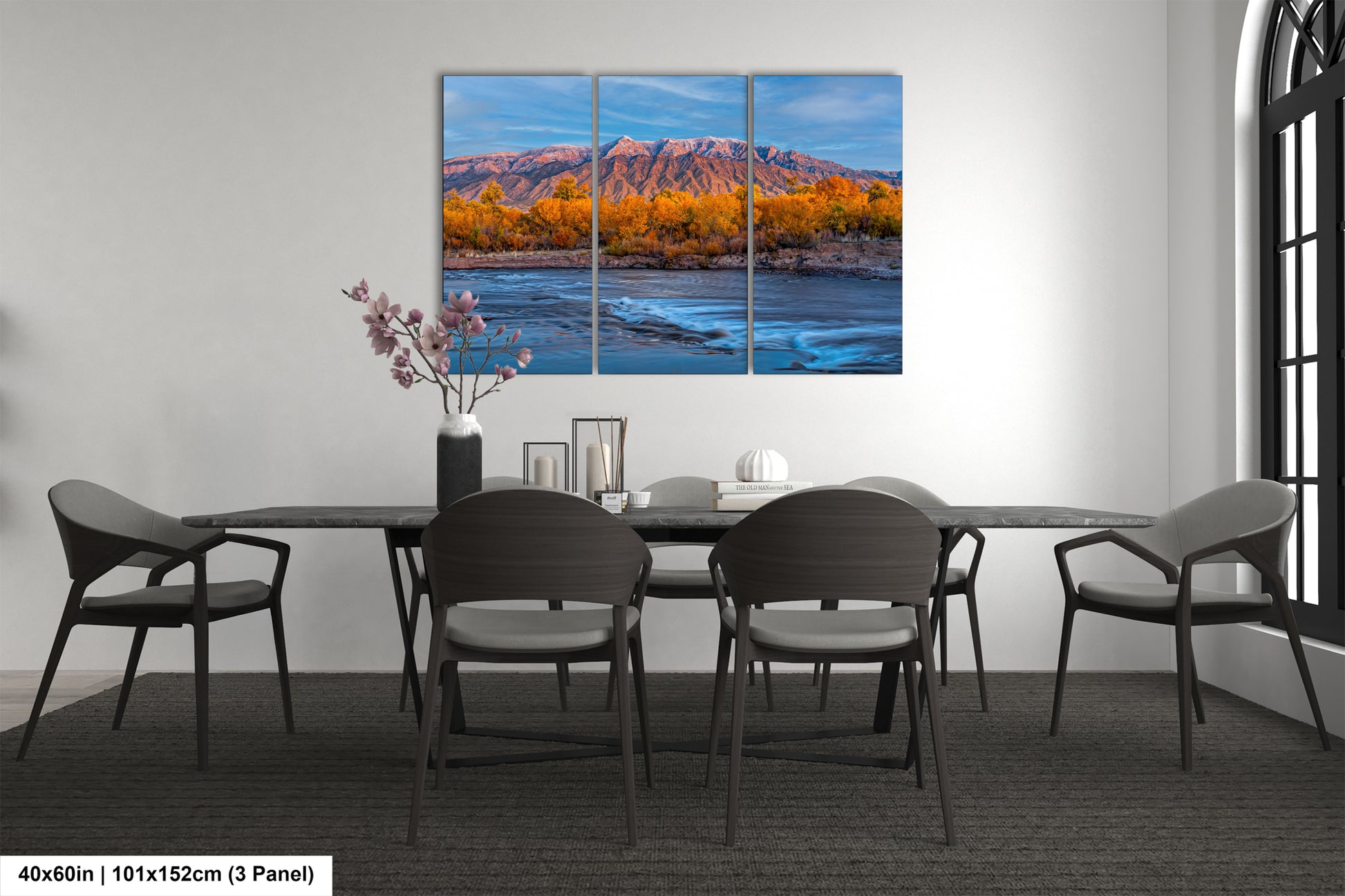 a dining room table with chairs and a painting on the wall