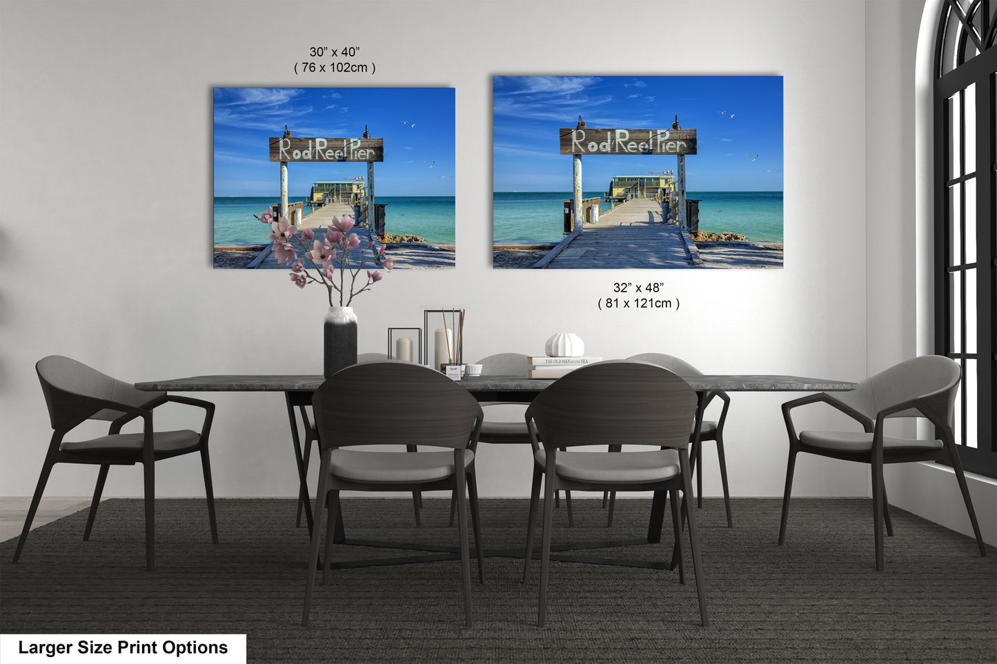 a dining room table with four chairs and two pictures on the wall
