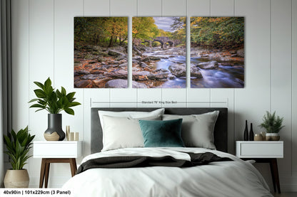 a bed room with a neatly made bed and two paintings on the wall