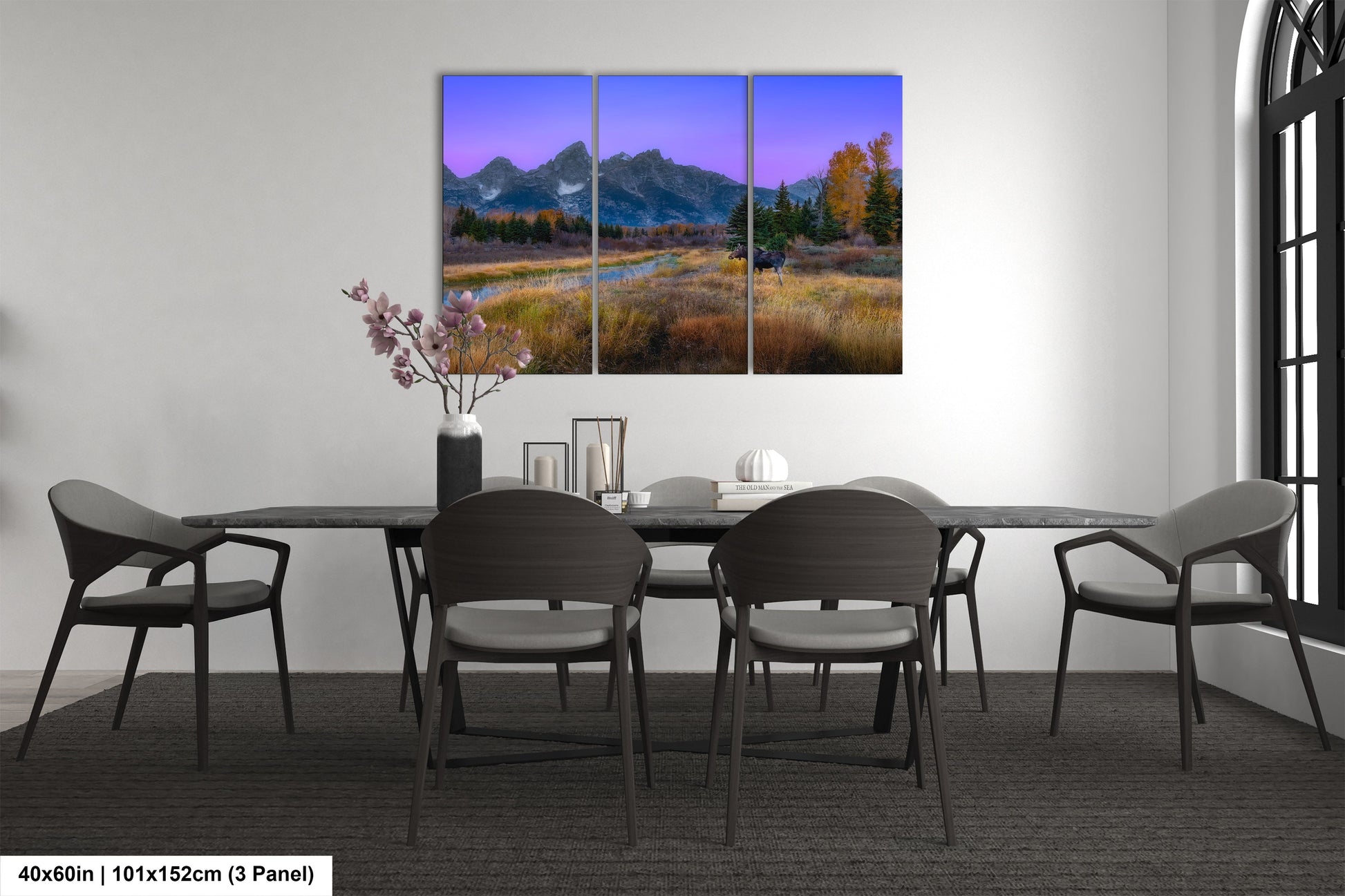 a dining room table with chairs and a painting on the wall