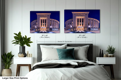 a bedroom with a large bed and two framed pictures of Yankee Stadium, a baseball stadium, hanging on the wall above it.