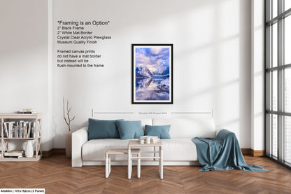 a living room with a white couch and a painting on the wall