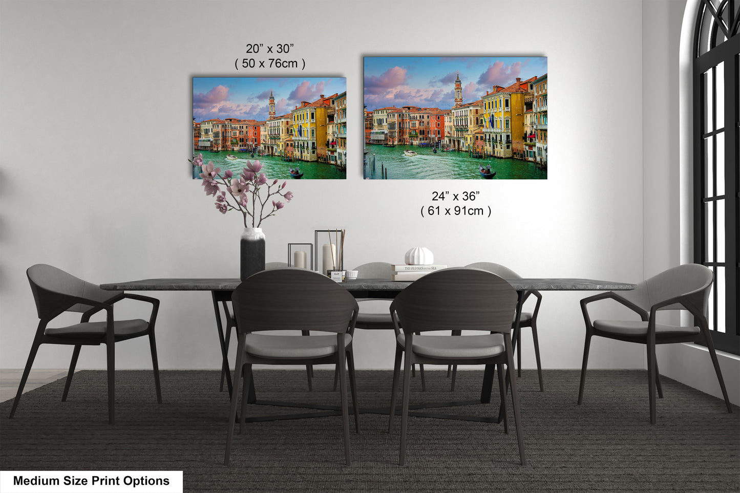 a dining room table with four chairs and a vase of flowers