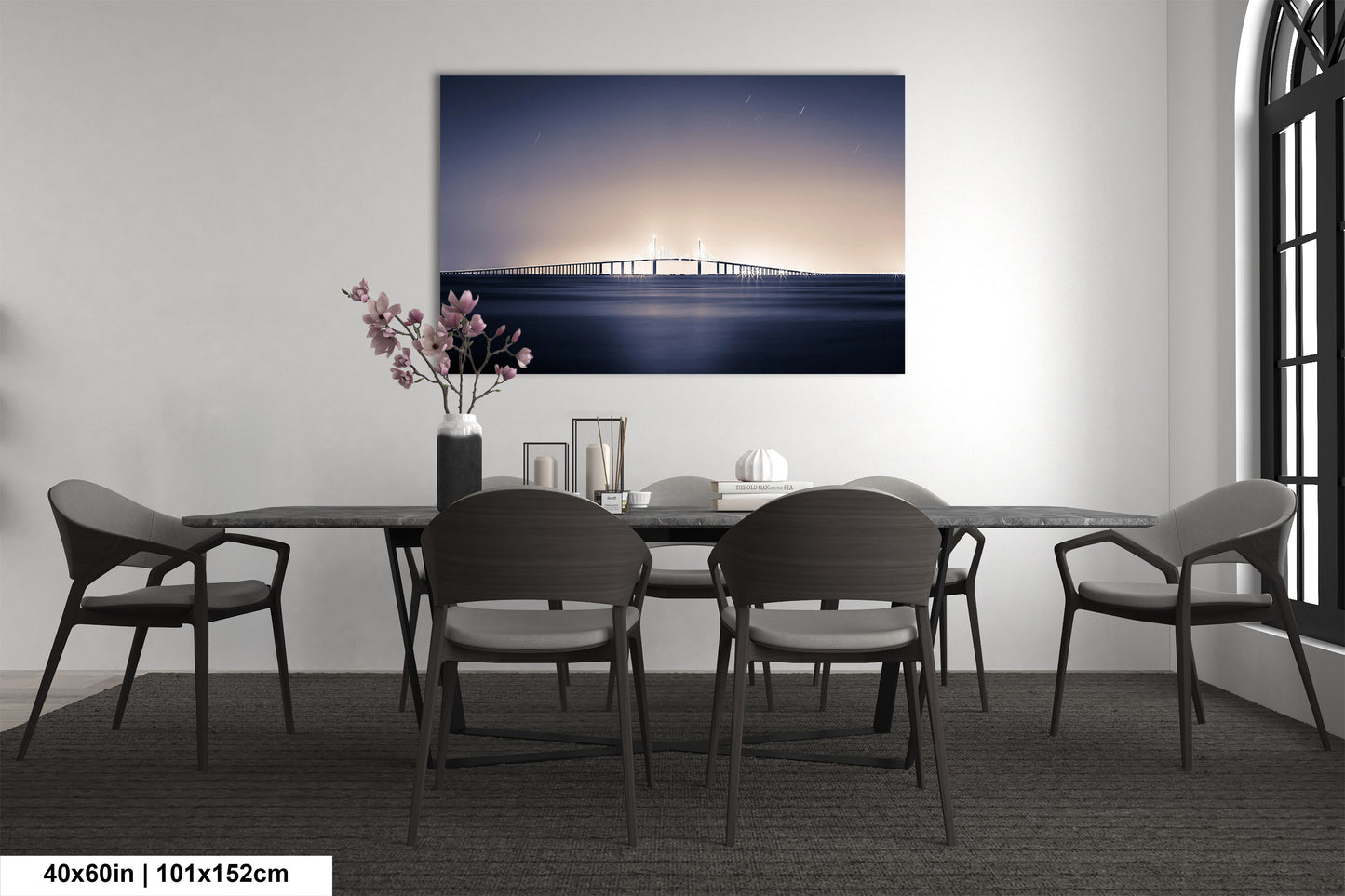 a dining room table with chairs and a painting on the wall