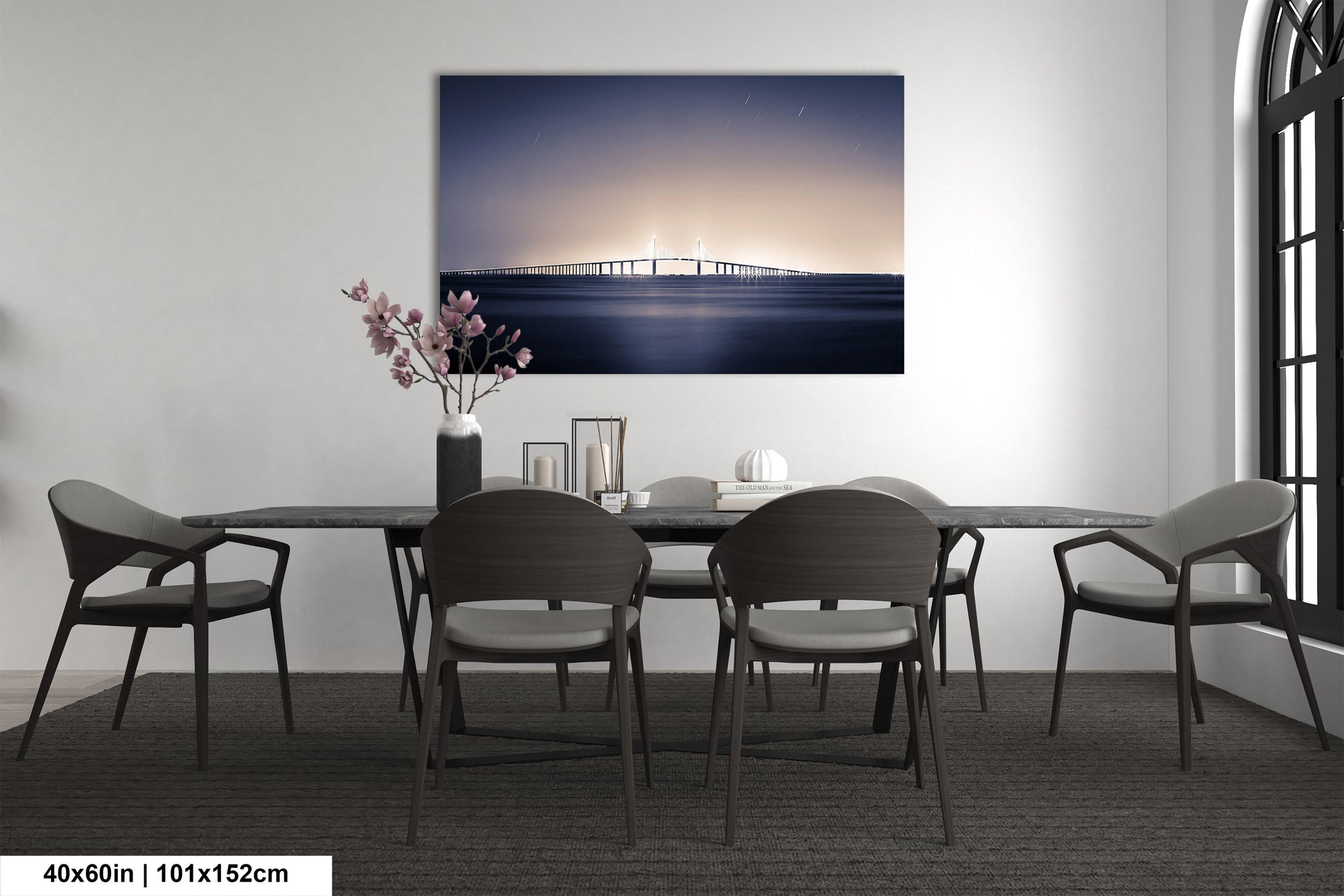 a dining room table with chairs and a painting on the wall