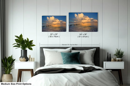a bedroom with a bed and two pictures on the wall
