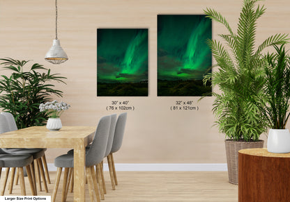 a modern dining room with a wooden table and chairs, a potted plant, and two framed prints of the northern lights on the wall.