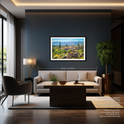 a modern living room with a large framed landscape painting hanging on the wall, a white sofa, a wooden coffee table, and a large window overlooking a desert landscape.