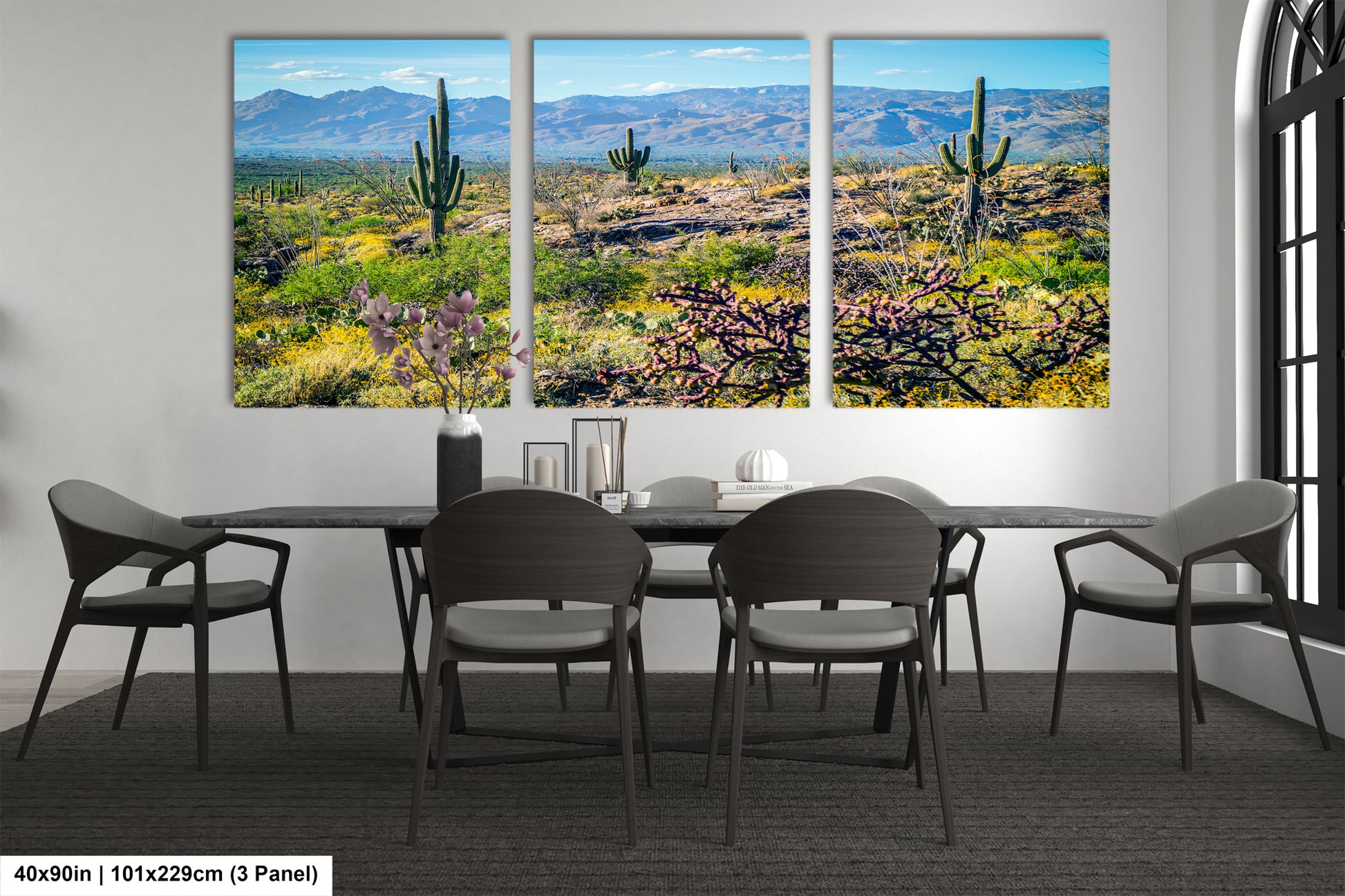 The image is a large, three-panel landscape painting depicting a desert scene with mountains in the background.