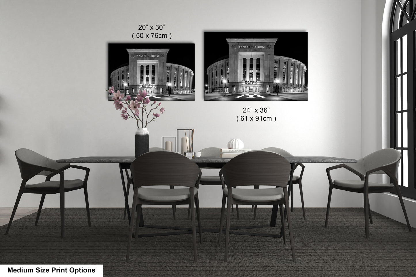 a dining room with a long table and four chairs. There are two framed black and white photographs of the Yankee Stadium, which is a baseball stadium located in New York City. The photographs are hung on the wall above the table, and the text indicates the size of the prints in inches.