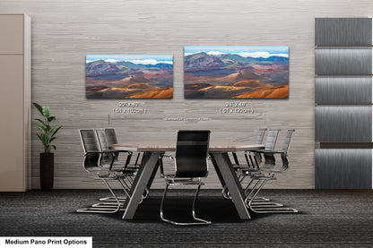 a modern office space with a large wooden table surrounded by black chairs. Two framed landscape paintings are displayed on the wall above the table, depicting a mountainous desert scene. The paintings are of similar size and style, and the text indicates that they are medium pano print options.