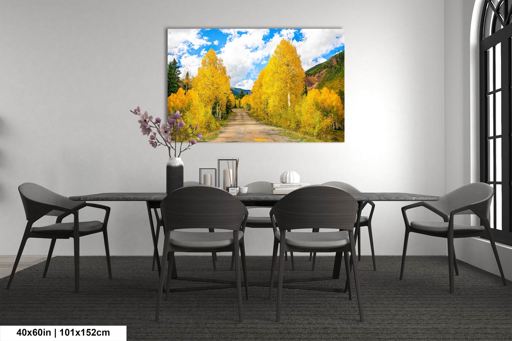 a dining room table with chairs and a painting on the wall