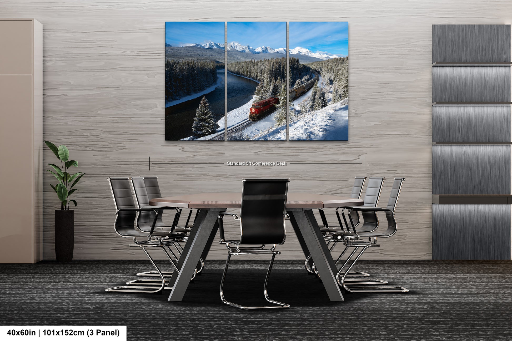 The image is a modern office space with a large, three-panel landscape painting depicting a snowy mountain scene with a train passing through. The painting is mounted on the wall above a wooden table surrounded by chairs.