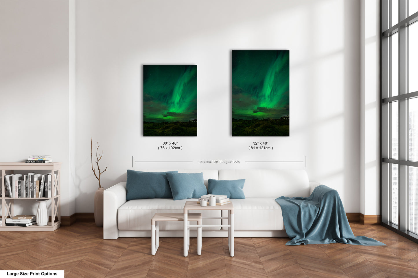 a living room with a white sofa, a coffee table, and a bookshelf. There are two framed pictures of the northern lights hanging on the wall above the sofa.