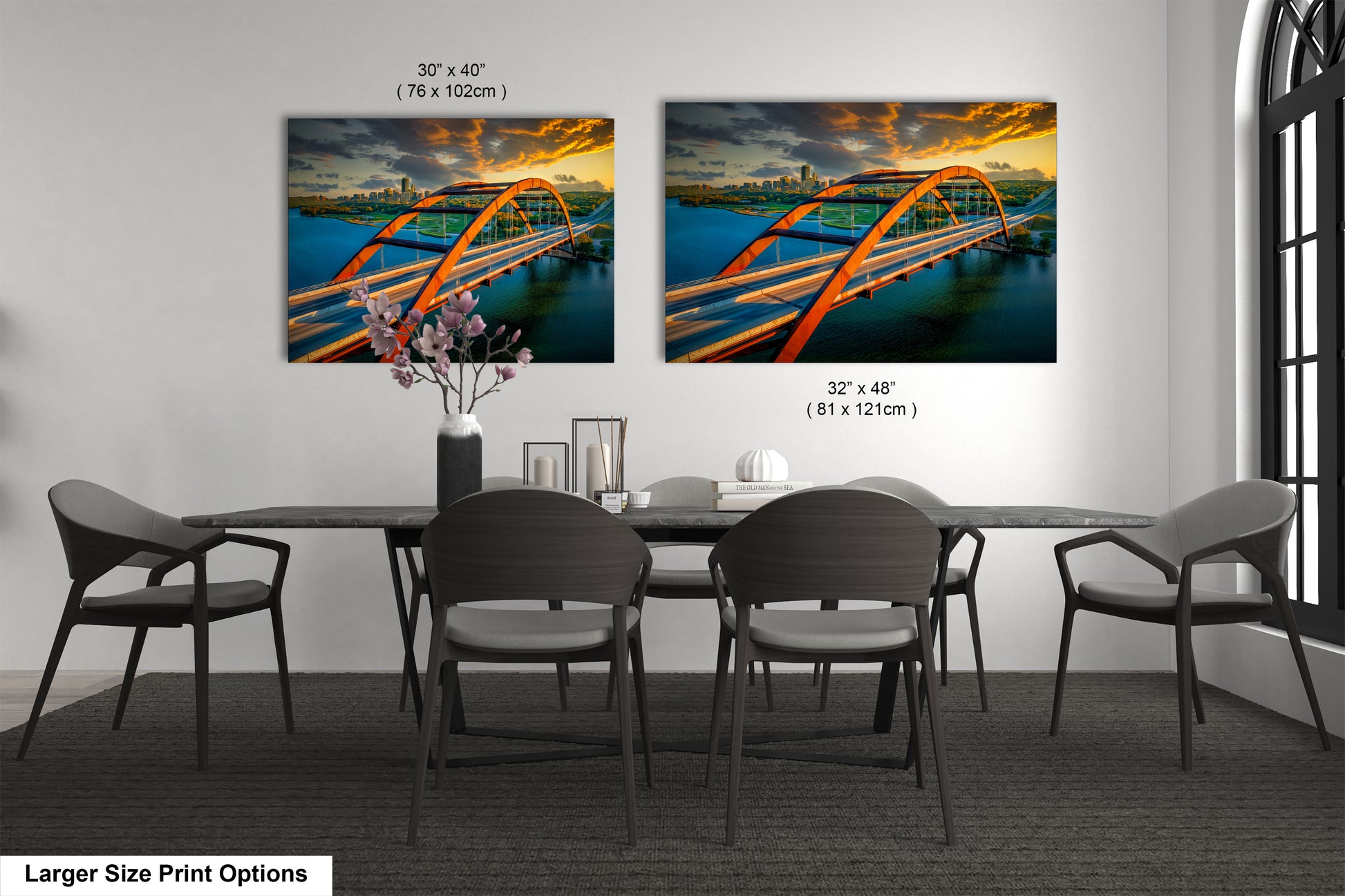 a dining room table with four chairs and a painting of a bridge