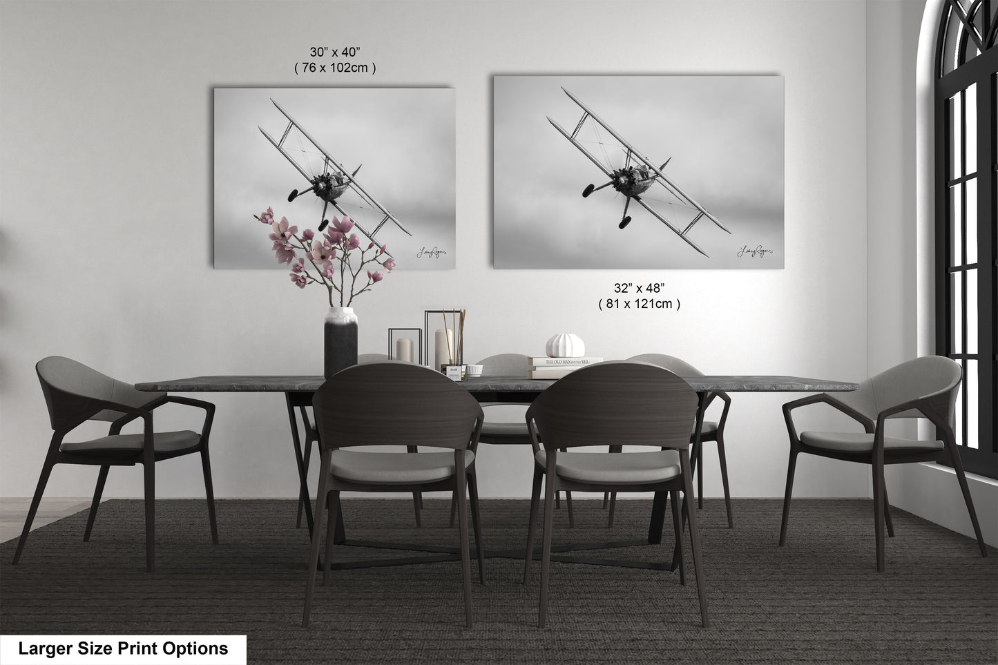 a dining table with four chairs and a vase of flowers