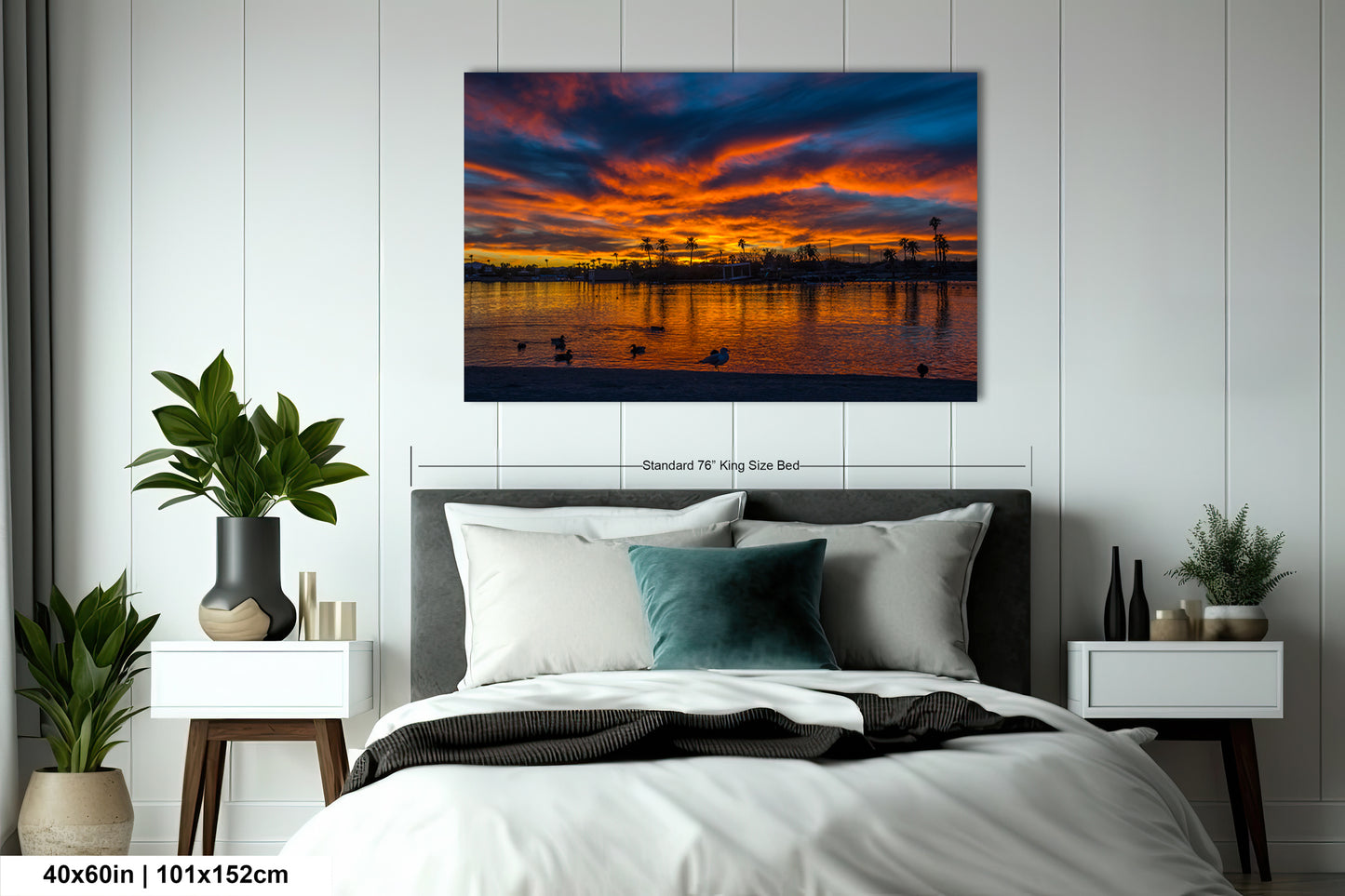 a serene bedroom scene with a large bed, nightstands, and a painting of a sunset over a body of water.