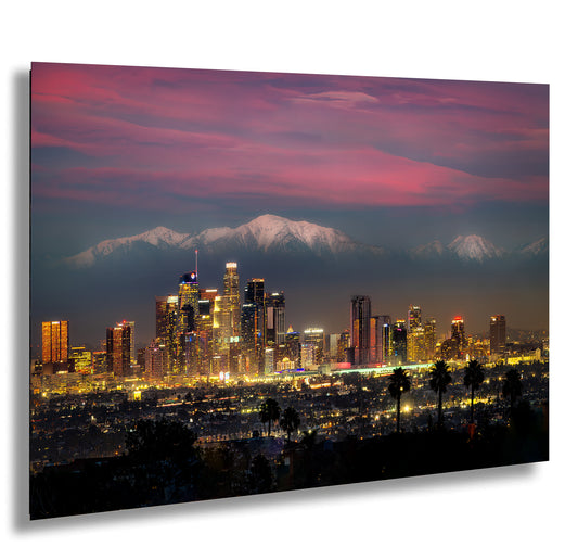 a view of a city at night with mountains in the background