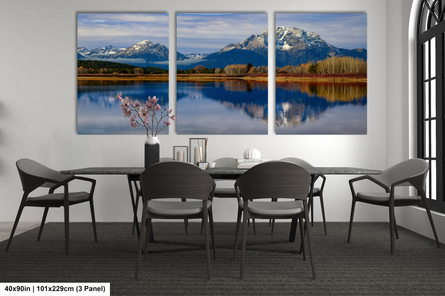 a dining room table with four chairs and three paintings on the wall