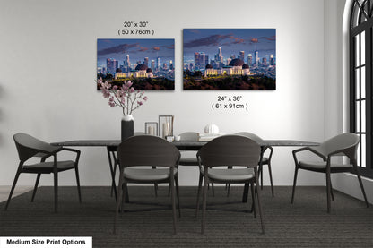 a dining room table with four chairs and a vase of flowers