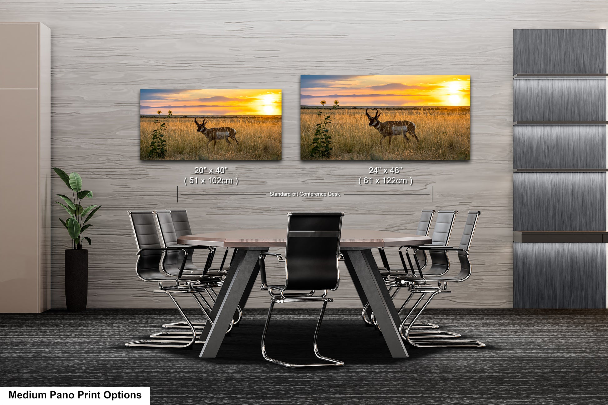 a modern office space with a large wall featuring two framed landscape paintings depicting a sunset over a field with a deer. The paintings are hung at eye level, and the chairs in front of the wall are arranged around a wooden table.