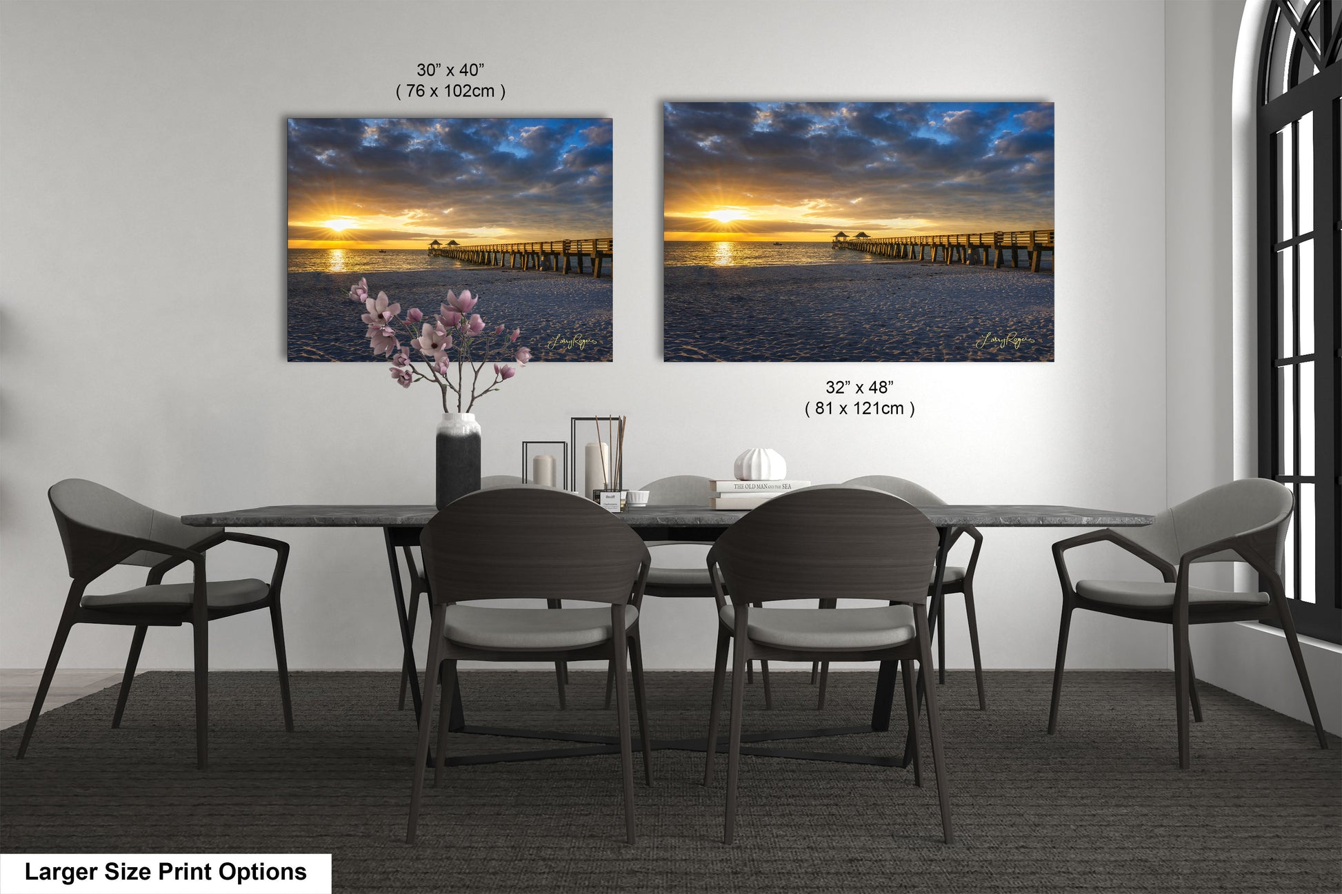 a dining room table with four chairs and two pictures on the wall