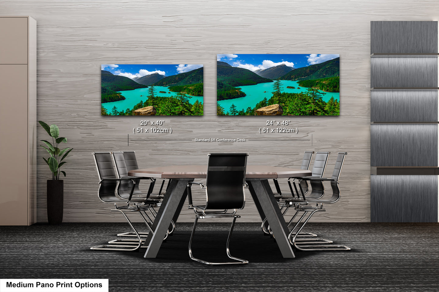 a modern office or conference room with a large wooden table surrounded by black chairs. Two framed landscape photographs are displayed on the wall above the table, depicting a scenic mountain landscape with turquoise water. The photographs are approximately 20 inches by 24 inches in size.
