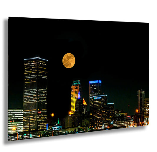 a full moon rises over a city at night