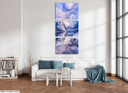 a living room with a white couch and a painting on the wall
