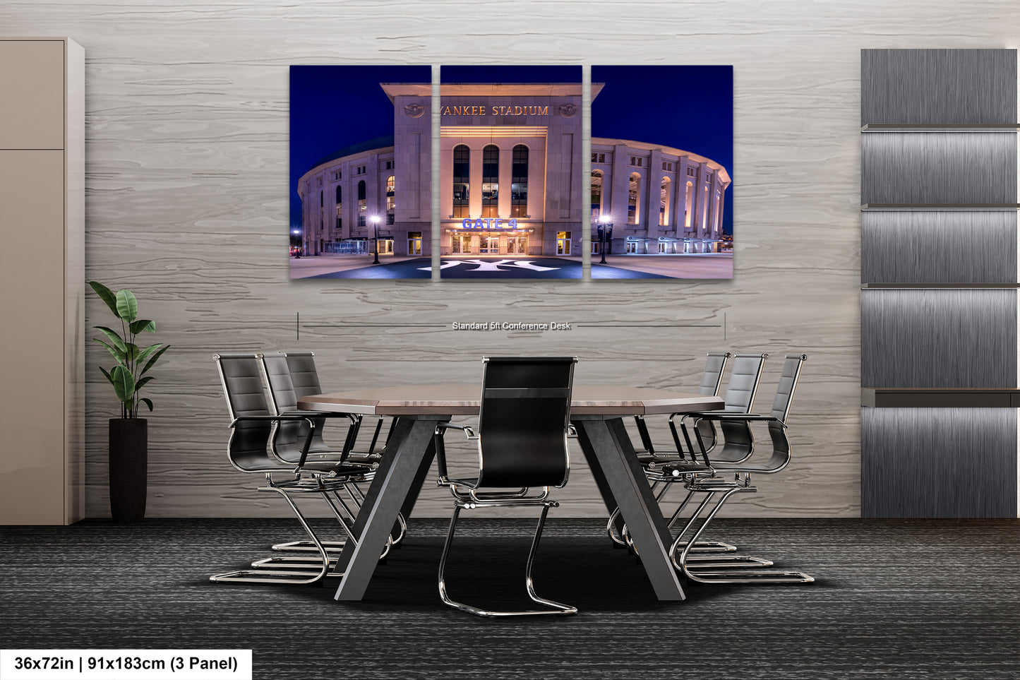 A modern office space with a large, circular building in the background, likely a stadium or arena, illuminated at night. The office has a conference table surrounded by chairs, and there is a plant in the corner.