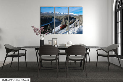 The image is a modern dining room with a large, three-panel landscape painting depicting a snowy mountain scene with a train passing through the valley. The painting is hung on the wall above a black dining table surrounded by six chairs.