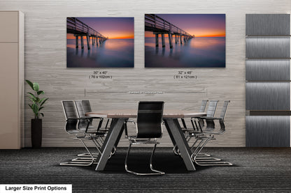 a dining room table with chairs and two pictures of a pier